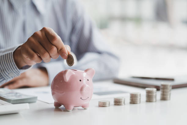 Business man hand putting coins in pink piggy bank with money stack step up growing growth. Planning step up, saving money for future plan, retirement fund. Business investment-finance account concept.